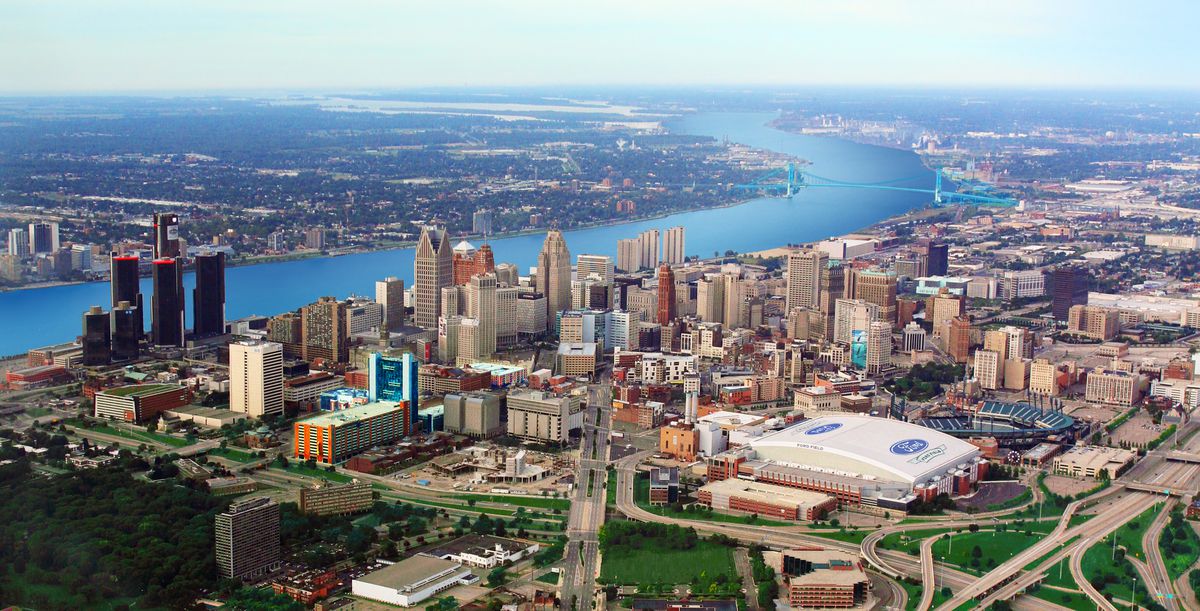 This aerial view, shot from low altitude in a small plane, shows most of downtown Detroit, Michigan. Included in the shot is Ford Field, home of the Detroit Lions, Comerica Park, home of the Detroit Tigers, the Ambassador Bridge, and the Detroit skyline. The Detroit River bisects the image.