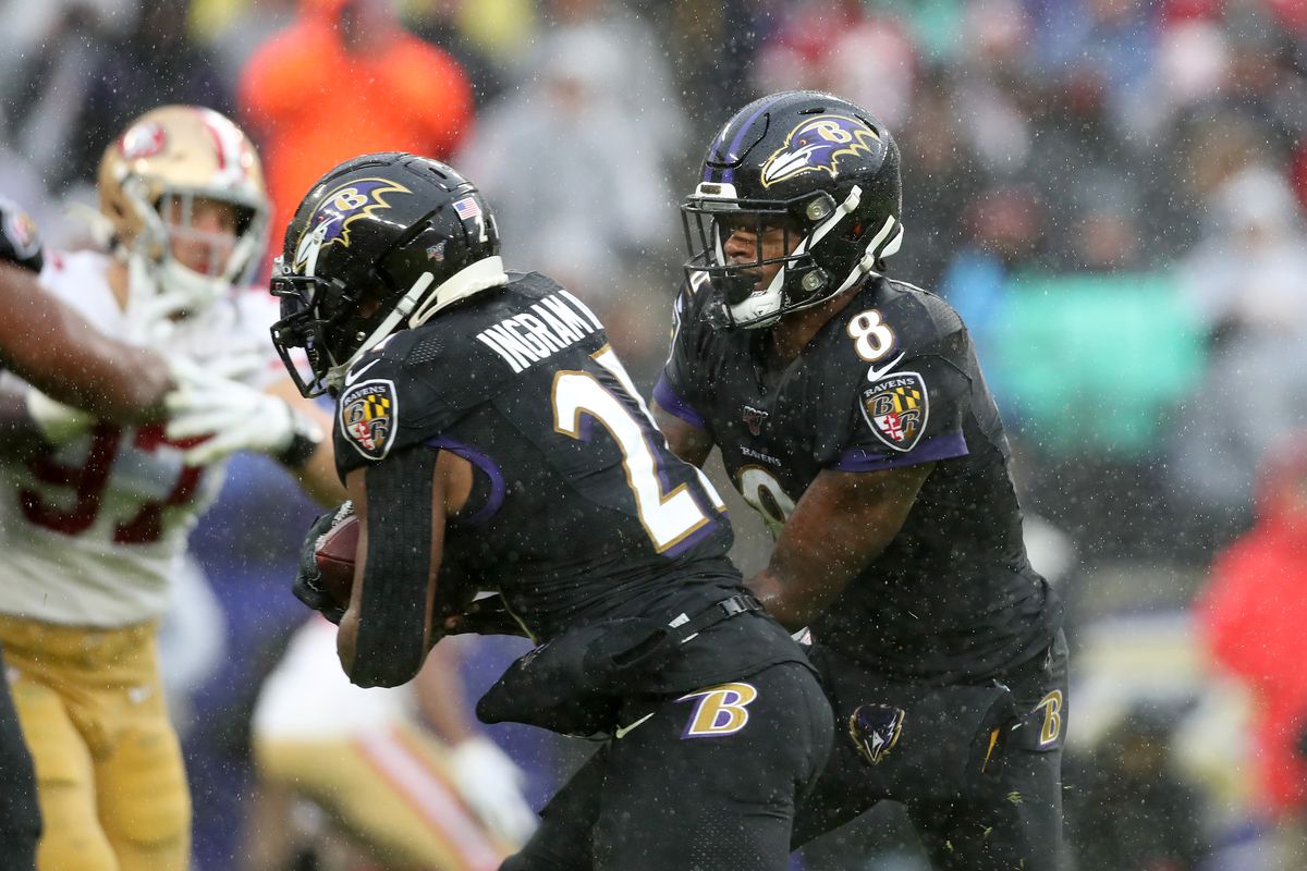 Lamar Jackson of the Baltimore Ravens hands the ball off to Mark Ingram against the San Francisco 49ers after throwing a first quarter touchdown pass at M&amp;T Bank Stadium on December 01, 2019 in Baltimore, Maryland.