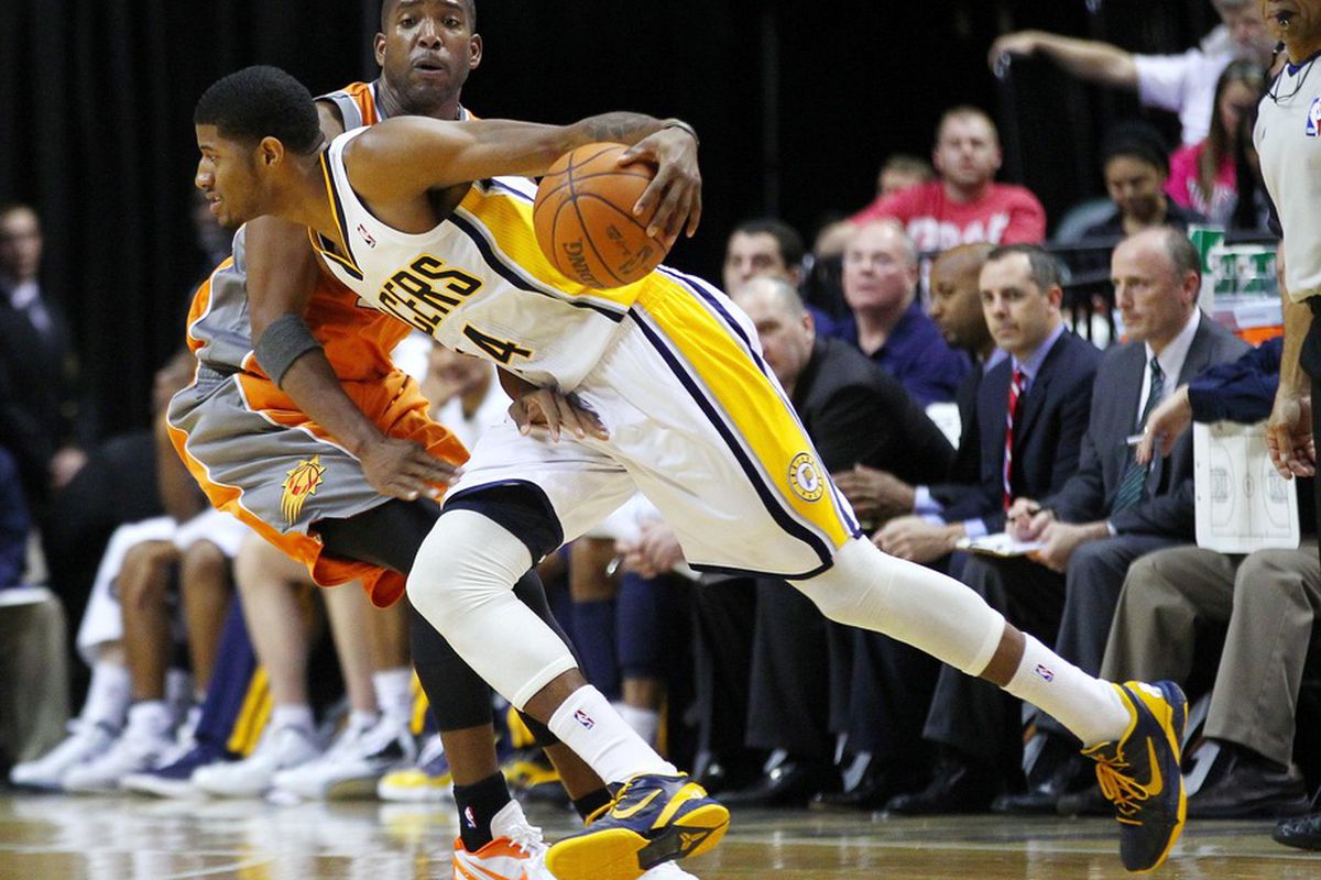 March 23, 2012; Indianapolis, IN, USA; Indiana Pacers shooting guard Paul George (24) drives the ball around Phoenix Suns shooting guard Michael Redd (22) at Bankers Life Fieldhouse. Mandatory credit: Michael Hickey-US PRESSWIRE