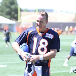 QB Peyton Manning holds his blue football and enjoys a laugh after practice
