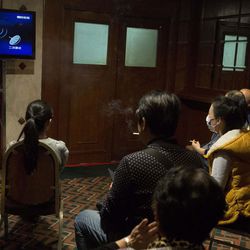 In this March 15, 2014, file photo, relatives of Chinese passengers aboard the missing Malaysia Airlines flight MH370 watch a news program about satellite tracking of the plane at a hotel in Beijing Saturday. 