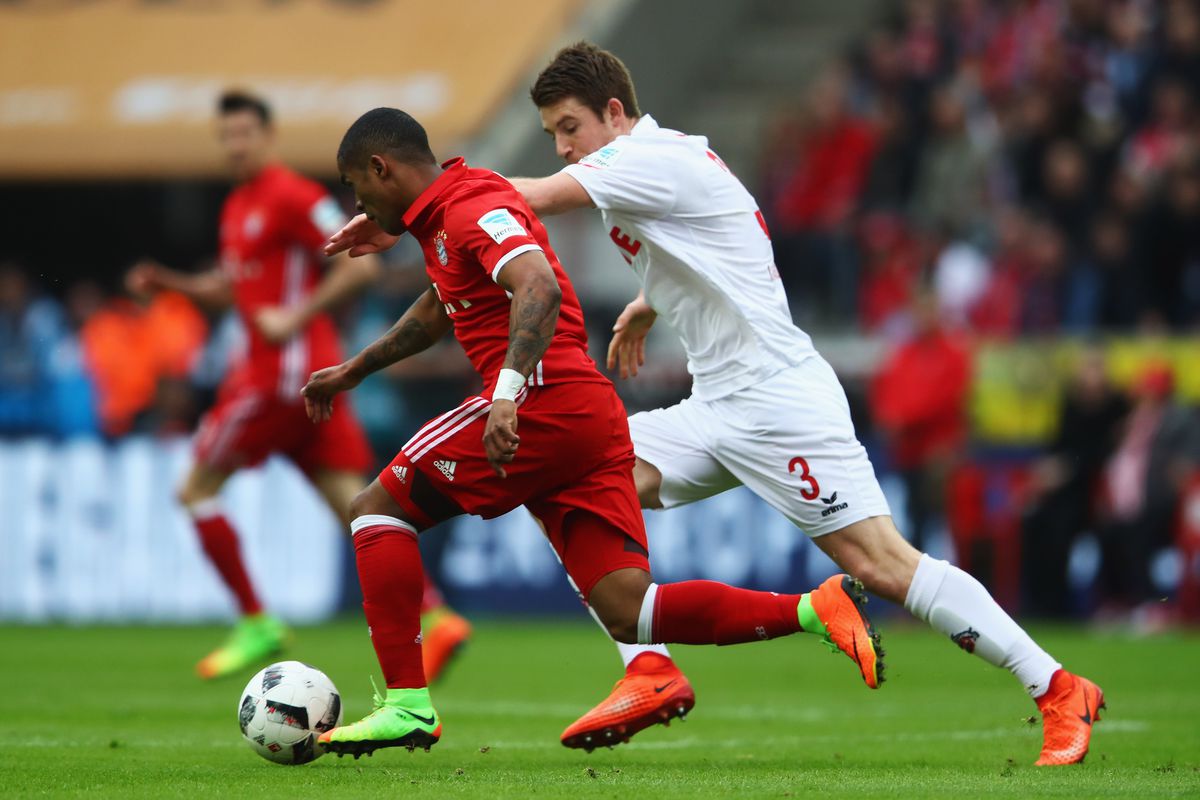 COLOGNE, GERMANY - MARCH 04: Douglas Costa of Bayern Munich gets past the tackle from Dominique Heintz of Koeln during the Bundesliga match between 1. FC Koeln and Bayern Muenchen at RheinEnergieStadion on March 4, 2017 in Cologne, Germany. (Photo by Dean Mouhtaropoulos/Bongarts/Getty Images)
