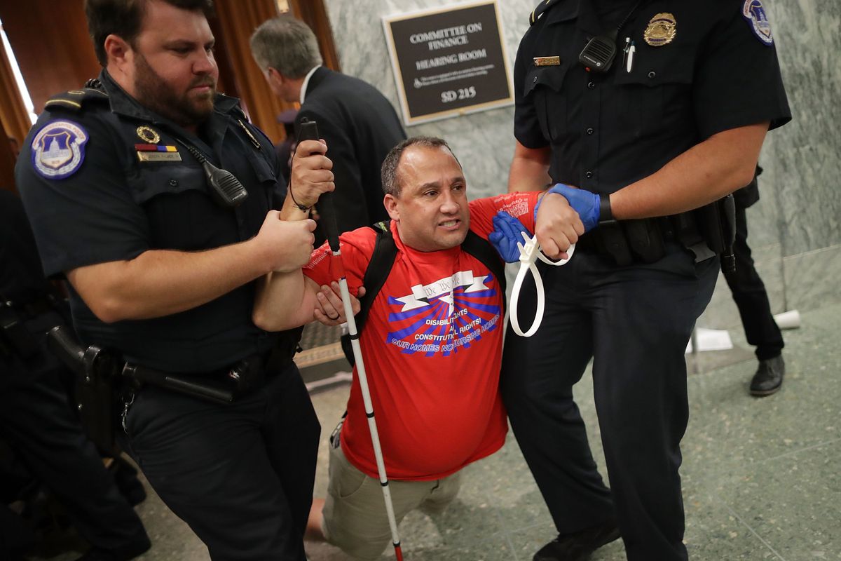 US Capitol Police drag a blind protester out of a Senate Finance Committee hearing about the proposed Graham-Cassidy health care bill, September 25. 