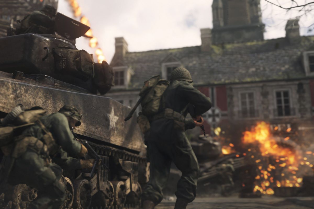 Soldiers fight alongside a tank in a screenshot from Call of Duty: WWII