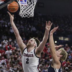 Gonzaga forward Drew Tim, left, shoots in front of BYU forward Caleb Loner during the first half of an NCAA college basketball game, Thursday, Jan. 13, 2022, in Spokane, Washington.