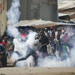 Supporters of Kenyan opposition leader and presidential candidate Raila Odinga throw back a tear gas canister at Kenyan security forces in the Mathare slum of Nairobi Wednesday , Aug. 9, 2017. Odinga alleges that hackers manipulated the Tuesday election results which appear to show President Uhuru Kenyatta has a wide lead over Odinga. (AP Photo/Jerome Delay)