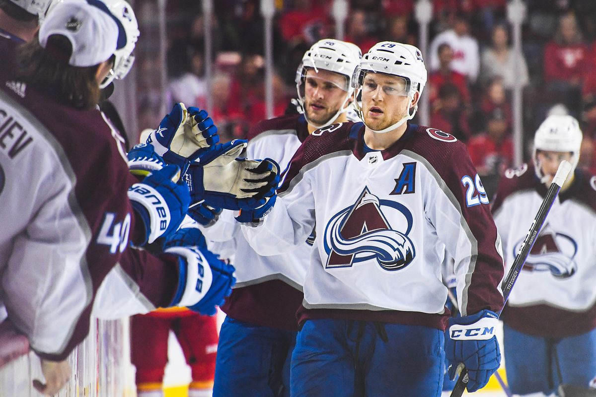 Nathan MacKinnon of the Colorado Avalanche celebrates with the bench after scoring against the Calgary Flames during an NHL game at Scotiabank Saddledome on October 13, 2022 in Calgary, Alberta, Canada.