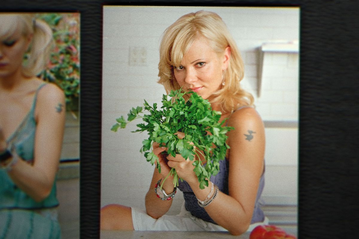 Still from “Bad Vegan” shows photo of woman holding up a bunch of cilantro and posing for the camera.