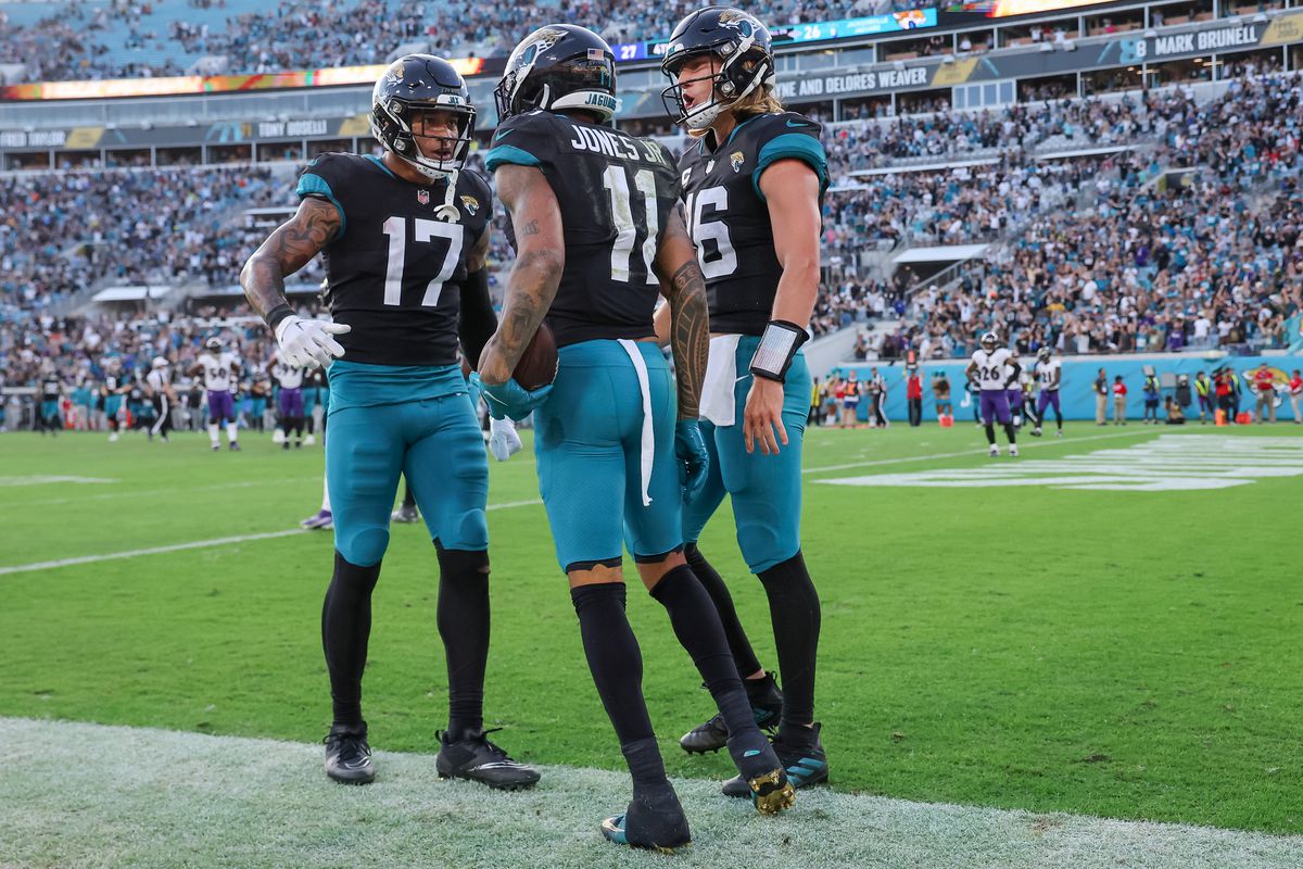 Marvin Jones Jr. #11 of the Jacksonville Jaguars celebrates a touchdown with Evan Engram #17 and Trevor Lawrence #16 against the Baltimore Ravens at TIAA Bank Field on November 27, 2022 in Jacksonville, Florida.