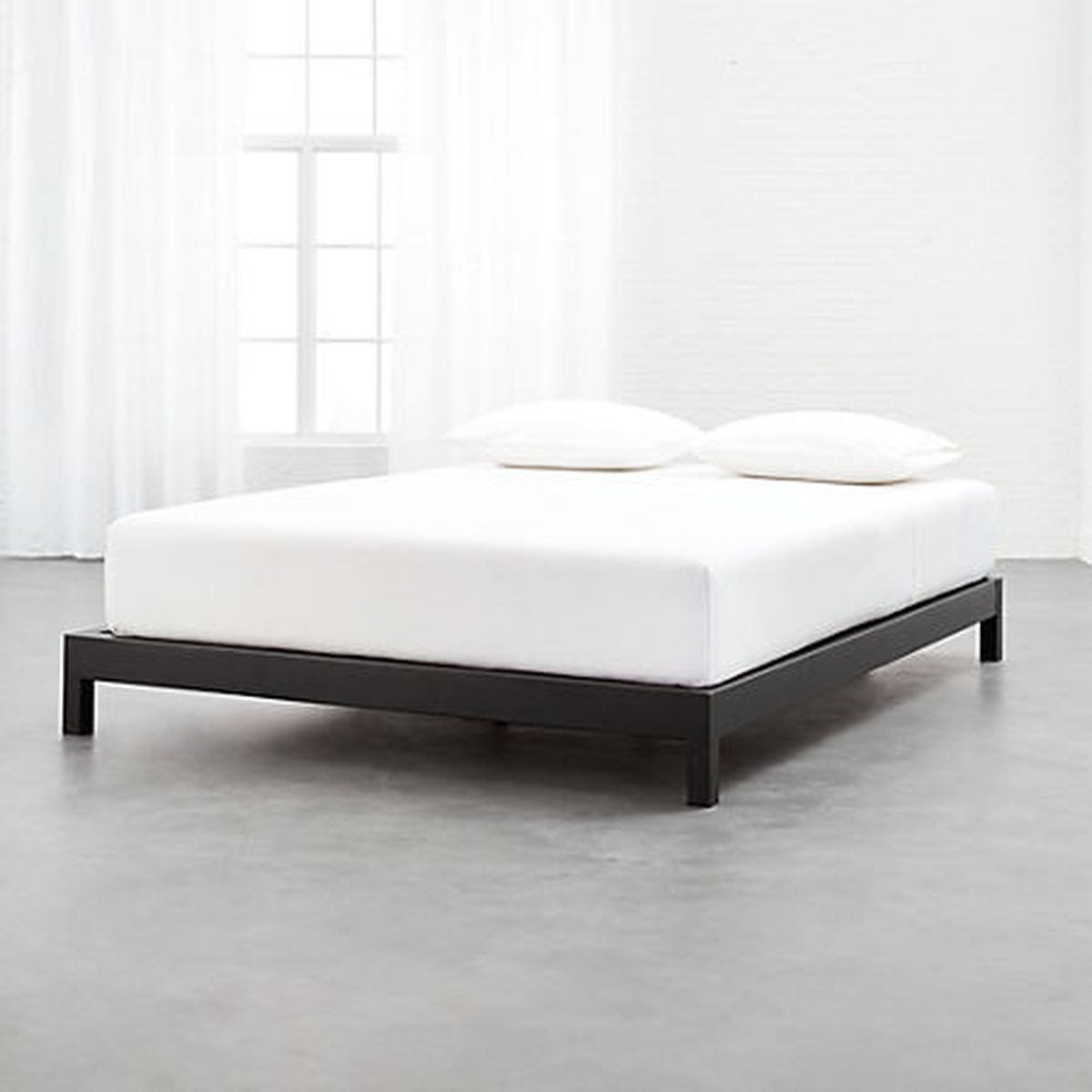 A black bed base with four legs. 