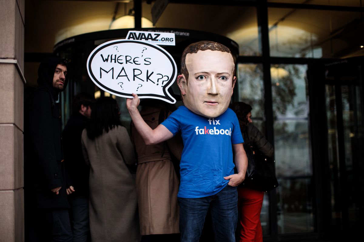 A protester wears a model head of Facebook CEO Mark Zuckerberg in London, England in November 2018.