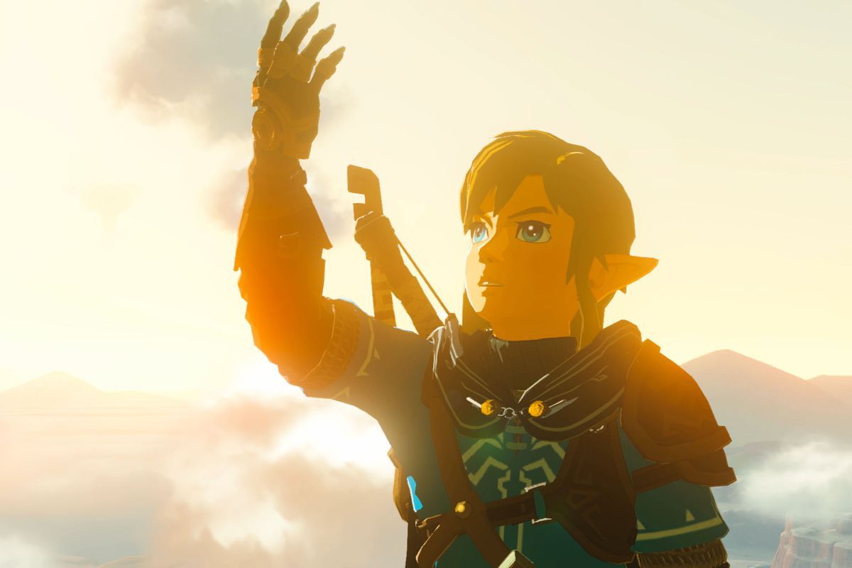 Link holds his prosthetic, infused arm, which he gained from Rauru, toward a twilit sky in The Legend of Zelda: Tears of the Kingdom