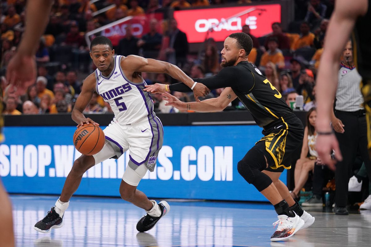 Sacramento Kings guard De’Aaron Fox (5) dribbles the ball next to Golden State Warriors guard Stephen Curry (30) in the second quarter during game three of the 2023 NBA playoffs at the Chase Center.