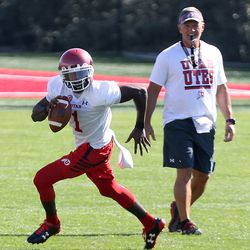 Utah QB Tyler Huntley runs past coach Kyle Whttngham during practice at Eccles Football Center at the University of Utah in Salt Lake City on Friday, July 28, 2017.