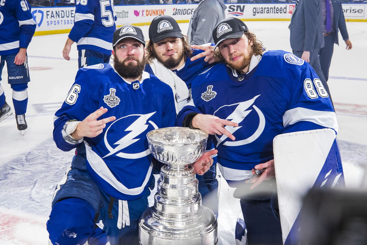 Nikita Kucherov #86, Mikhail Sergachev #98, and goalie Andrei Vasilevskiy #88 of the Tampa Bay Lightning celebrates with the Stanley Cup after defeating the Montreal Canadiens in Game Five to win the best of seven game series 4-1 during the Stanley Cup Final of the 2021 Stanley Cup Playoffs at Amalie Arena on July 7, 2021 in Tampa, Florida.