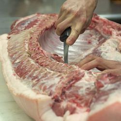 Prior to cutting the pig into thirds, remove the leaf lard and tenderloin. Remove shoulder section. Starting from the front of the hog count the fourth and fifth ribs and slice between them thus separating the shoulder from the middle section. 