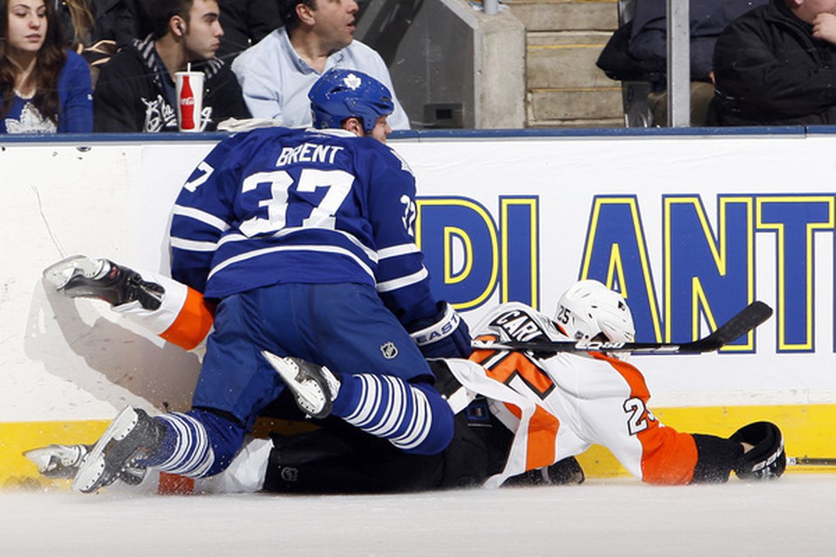 TORONTO CANADA - DECEMBER 9: Tim Brent #37 of the Toronto Maple Leafs runs into Matt Carle #25 of the Philadelphia Flyers during game action at the Air Canada Centre December 9 2010 in Toronto Ontario Canada. (Photo by Abelimages/Getty Images)