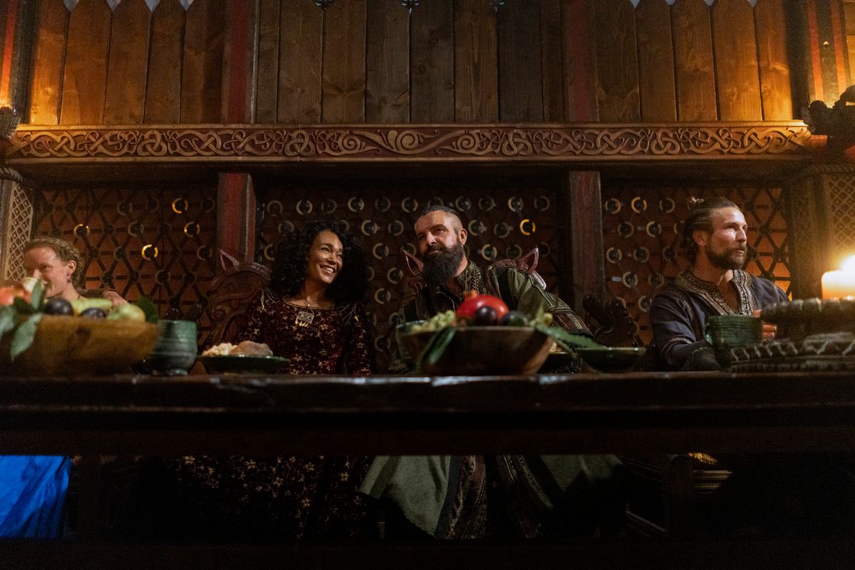 Haakon and Canute sitting at the feast table in a still from Vikings: Valhalla