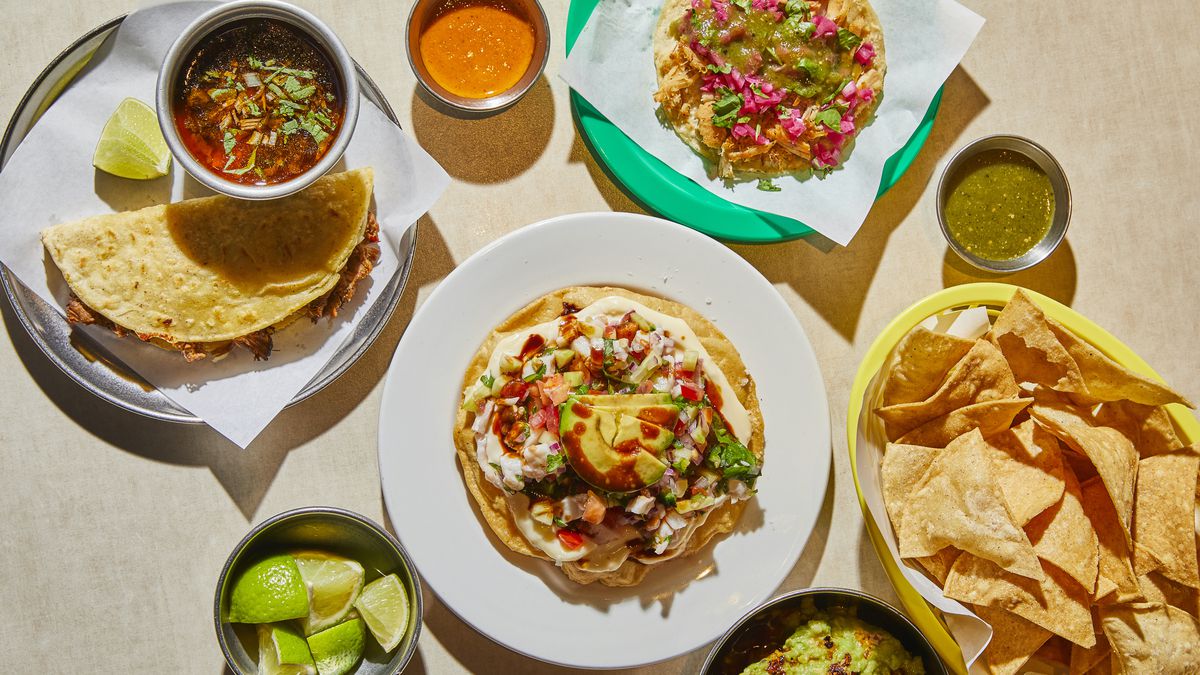 A bird’s-eye view of quesadillas with consomé; tostadas; and totopos on colourful plates.