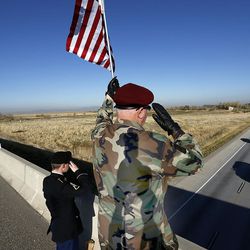 Pfc. Chase Davis, left, of the 850th Signal Company at Fort Douglas, and Vietnam veteran Bob Fillmore salute travelers while standing on the I-215 overpass at 2200 North in Salt Lake City on Friday, Nov. 11, 2016.