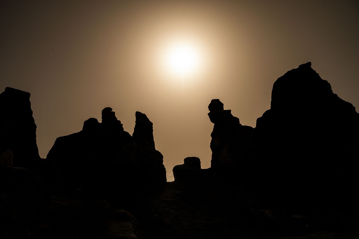 Silhouettes of volcanic rock formations shaped by the...