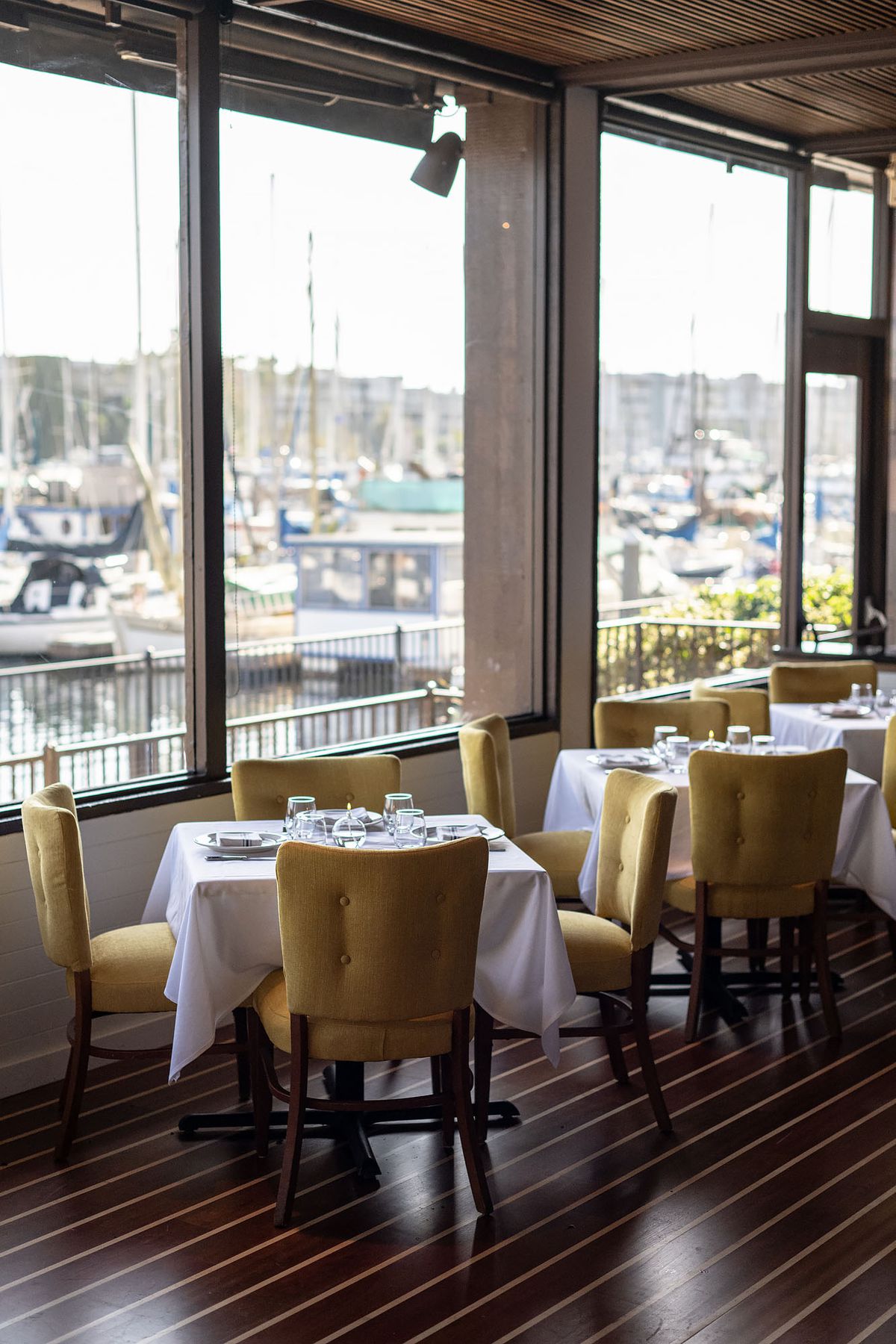 Yellow chairs, white tablecloths, and views of the marina at Dear Jane’s.