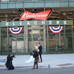 Sat 3:37 p.m. Wedding photos being taken outside the bleacher gate - 
