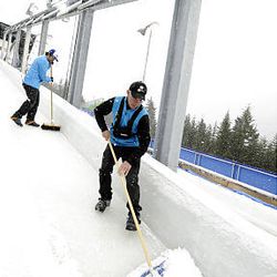Volunteers clear the snow at the start of the luge track during a heavy snowstorm at the Whistler Sliding Centre Thursday.