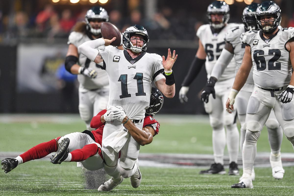 Philadelphia Eagles quarterback Carson Wentz passes while being tackled by Atlanta Falcons linebacker Vic Beasley during the fourth quarter at Mercedes-Benz Stadium.