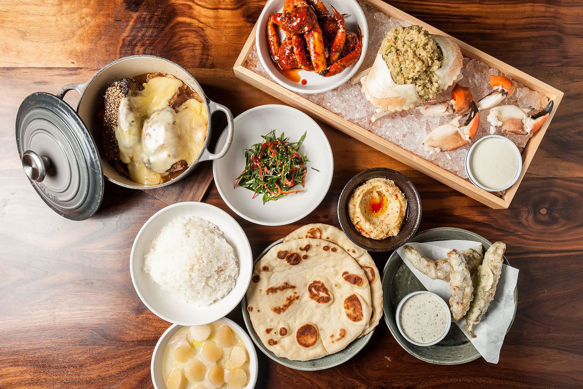 A spread that includes breads, hot pot dishes, vegetables and more.