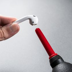 <em>Blow air up and into speaker grills and microphone holes. Let loose debris fall down and away from the earbud.</em>