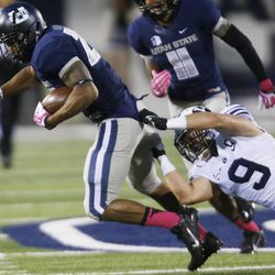 Utah State Aggies running back Joey DeMartino (28) is brought down by Brigham Young Cougars defensive back Daniel Sorensen (9) during the NCAA football game in Logan on Oct. 5.