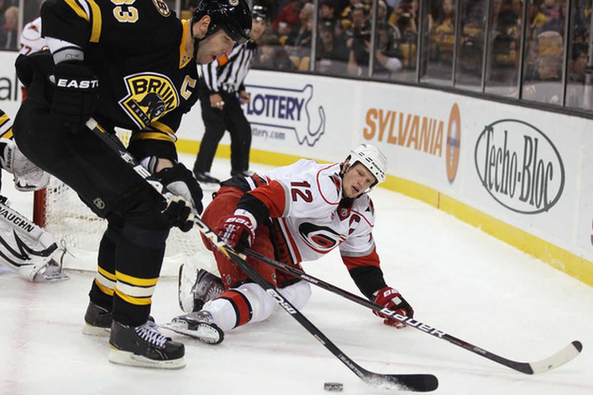 BOSTON - NOVEMBER 26:  Zdeno Chara #33 of the Boston Bruins takes the puck from Eric Staal #12 of the Carolina Hurricanes on November 26 2010 at the TD Garden in Boston Massachusetts.  (Photo by Elsa/Getty Images)