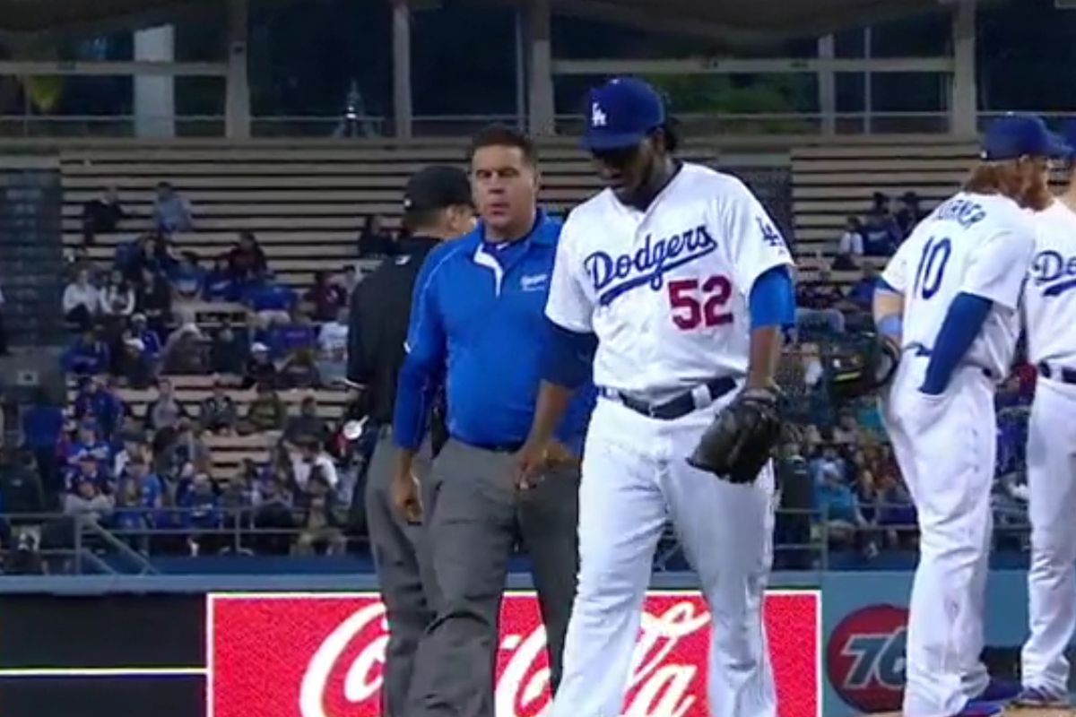 Pedro Baez and trainer Stan Conte walk off the field in the eighth inning on Wednesday night.