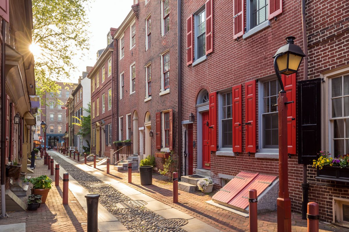 Elfreth’s Alley in Philadelphia. The houses that line the street are red brick with colorful shutters. 