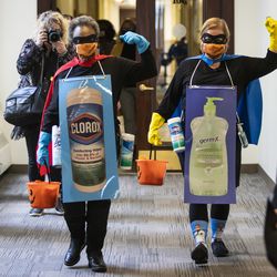 Mayor Lori Lightfoot and Dr. Allison Arwady, commissioner of the Chicago Department of Public Health, wear “Rona Destroyer” costumes walk through City Hall to a press conference about Halloween in Chicago, Thursday afternoon, Oct. 1, 2020.