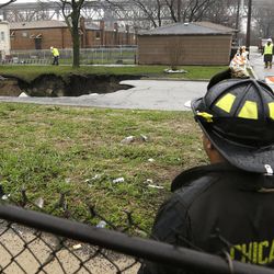 A gaping sinkhole opened up a residential street on Chicago's South Side after a cast iron water main dating back to 1915 broke during a massive rain storm on Thursday in Chicago. The hole spanned the entire width of the road and chewed up grassy areas abutting the sidewalk.  