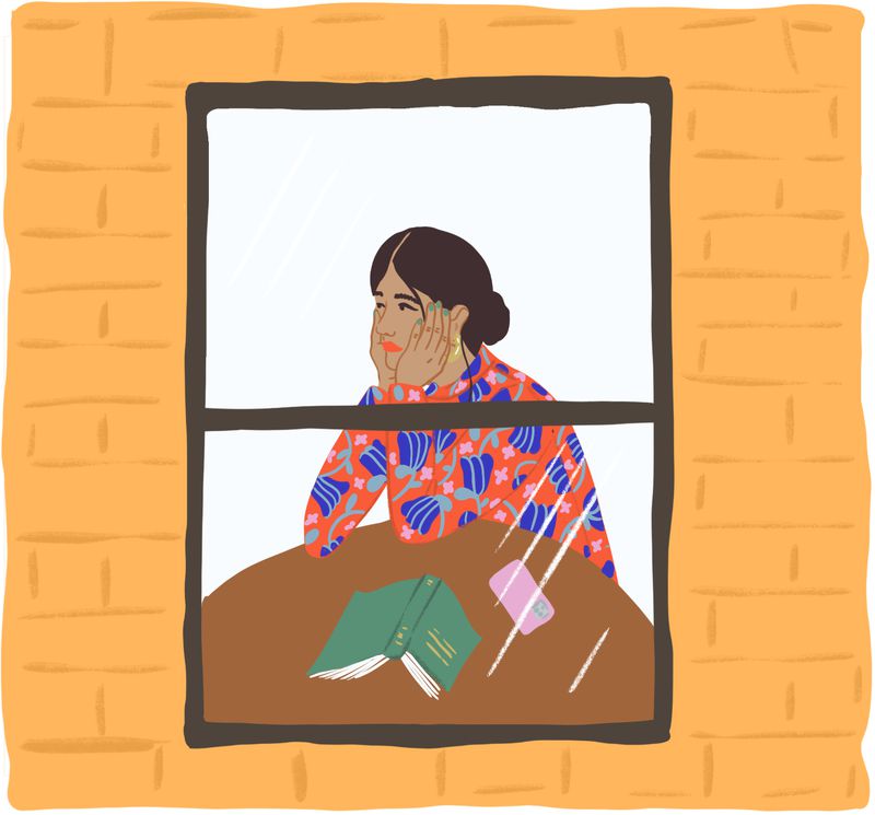 A single woman sits alone in her apartment, looking out the window