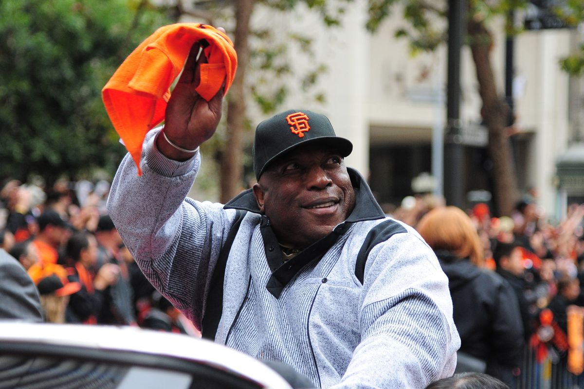Willie McCovey waiving a flag from a car at the Giants 2012 World Series parade.