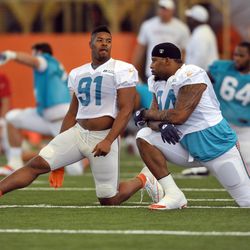 Jul 24, 2013; Davie, FL, USA; Miami Dolphins defensive end Cameron Wake (left) talks with teammate defensive tackle Randy Starks (right) during warms up during training camp at the Doctors Hospital Training Facility at Nova Southeastern University.