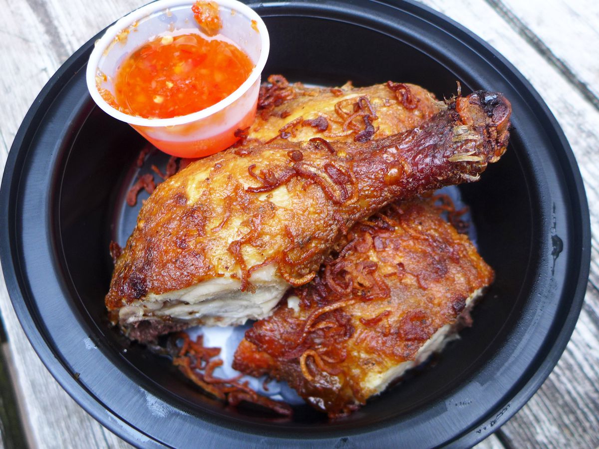 Several pieces of chicken with an orange dipping sauce.