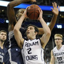 Brigham Young Cougars guard Matt Carlino (2) drives to the basket as Utah State Aggies center Jarred Shaw (5) defends during a game at EnergySolutions Arena on Saturday, November 30, 2013.