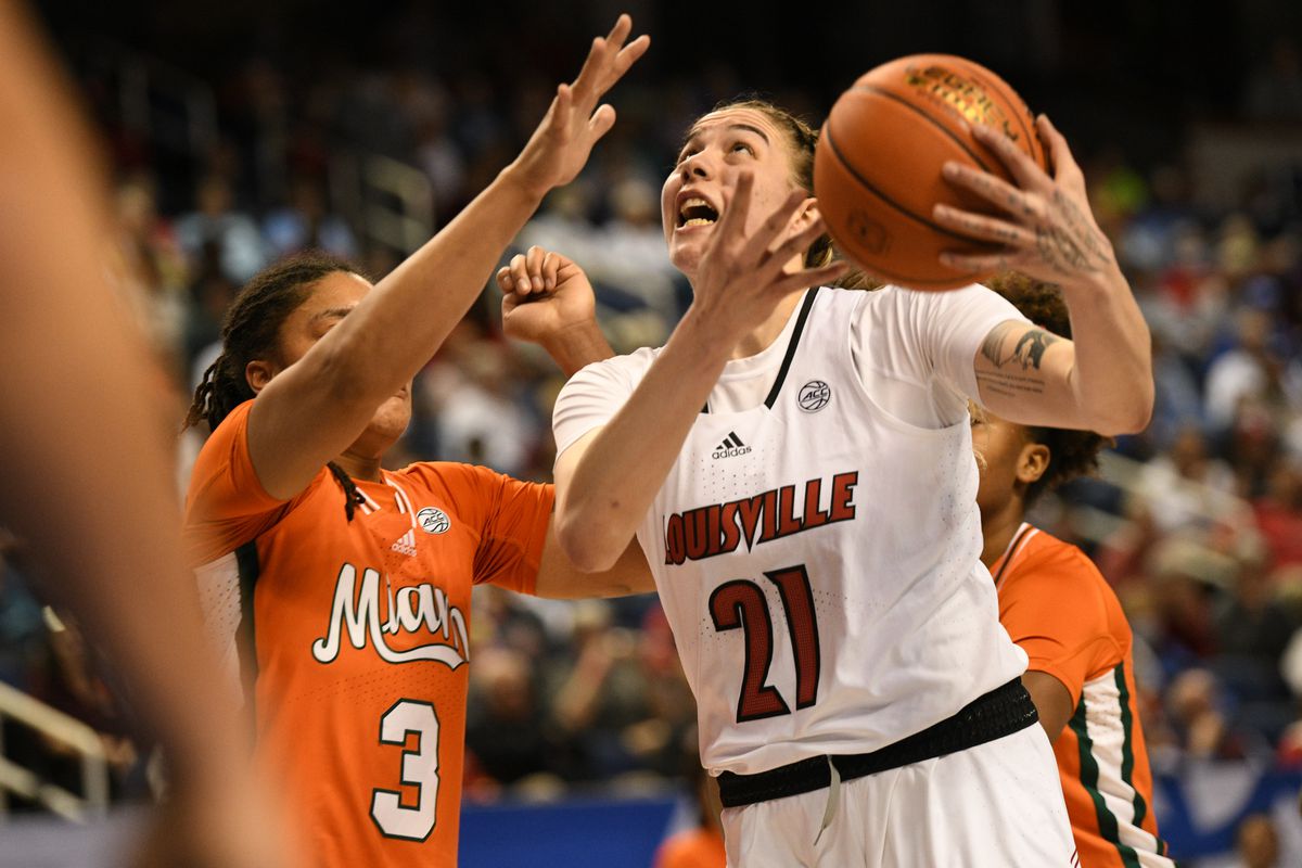 Louisville Cardinals forward Emily Engstler (21) drives against Miami Hurricanes forward Destiny Harden (3) during the second quarter at Greensboro Coliseum Complex. Mandatory Credit: William Howard