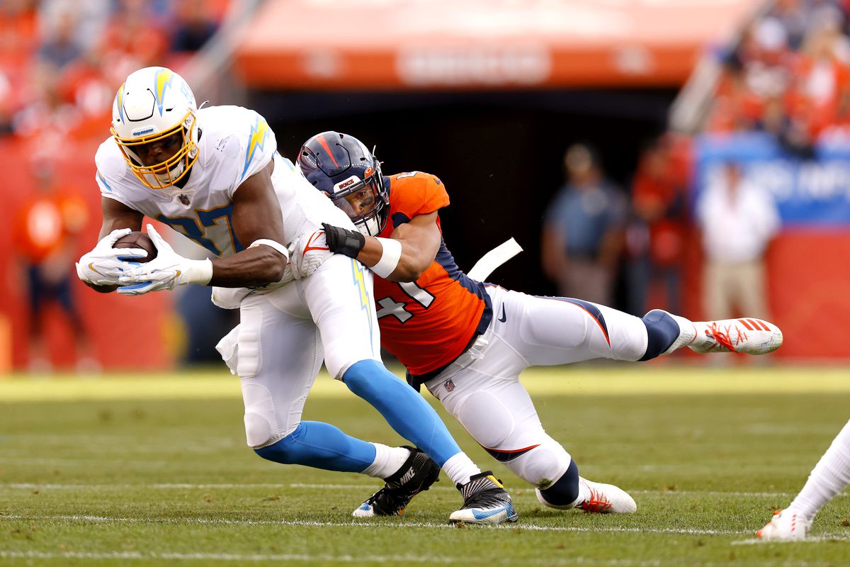 Jared Cook #87 of the Los Angeles Chargers catches a pass and is tackled by Kenny Young #41 of the Denver Broncos in the second quarter of the game at Empower Field At Mile High on November 28, 2021 in Denver, Colorado.