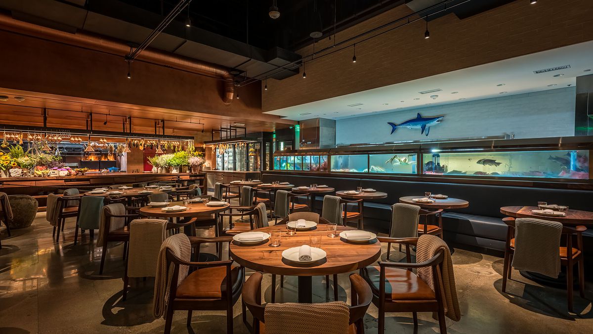 Dining room, dimly lit, with fish tanks and decor, at Angler, Los Angeles, California.