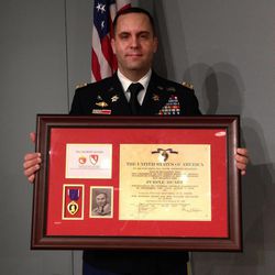 U.S. Army Lt. Col. Matthew Yandura holds Robert Mathis' Purple Heart medal and certificate Sunday, Nov. 13, 2016, in Farmington Hills, Mich. The medal and certificate are to be presented to Mathis' relatives Sunday during a ceremony at the Holocaust Memorial Center Zekelman Family Campus in Farmington Hills, northwest of Detroit. Mathis was killed during World War II. Yandura found Mathis' Purple Heart certificate in 2013 in a used map shop in Jerusalem. The Purple Heart will be returned to Mathis' family in a ceremony on Sunday. 
