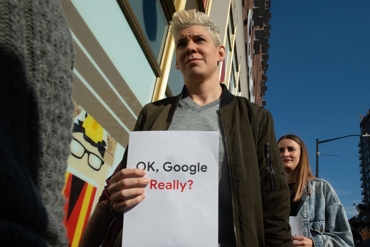 Google employees protest outside the company’s office in New York; one holds a sign that reads, “Ok Google really?”