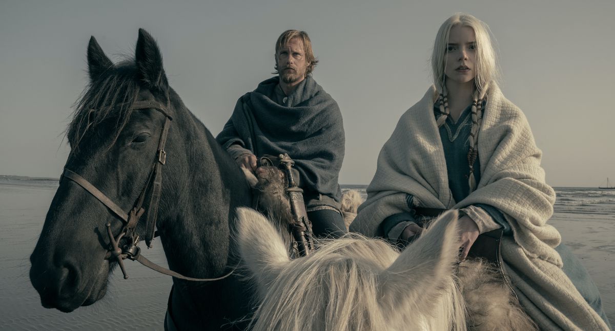 Alexander Skarsgård and Anya Taylor-Joy on horseback by the sea in The Northman