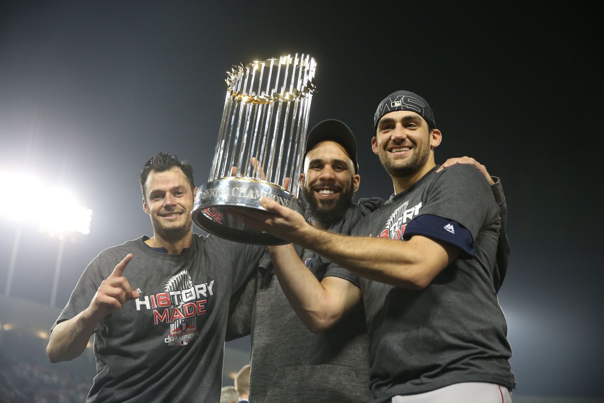 Red Sox players hold the Commissioner’s Trophy after winning the World Series.
