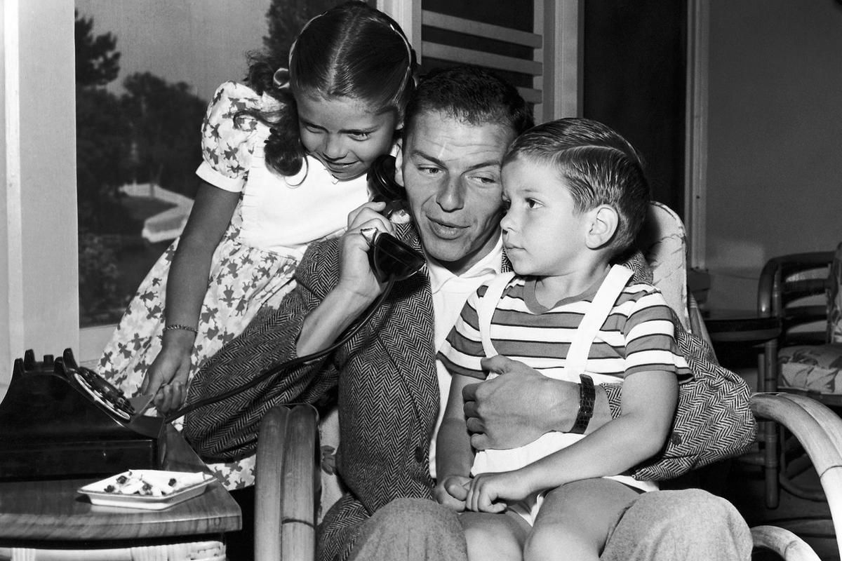 In this 1948 file photo, Frank Sinatra holds a telephone with his children, Nancy and Frank Jr., in the Hollywood area of Los Angeles. Frank Sinatra Jr., who carried on his famous father's legacy with his own music career, died unexpectedly of cardiac arr